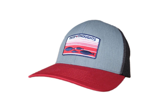 grey red and charcoal structured trucker cap with embroidered red white and blue patch showing fish swimming under ocean currents