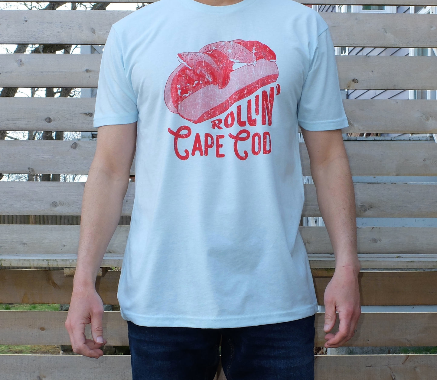 man wearing light blue t-shirt with red lobster roll graphic and Rollin' Cape Cod text