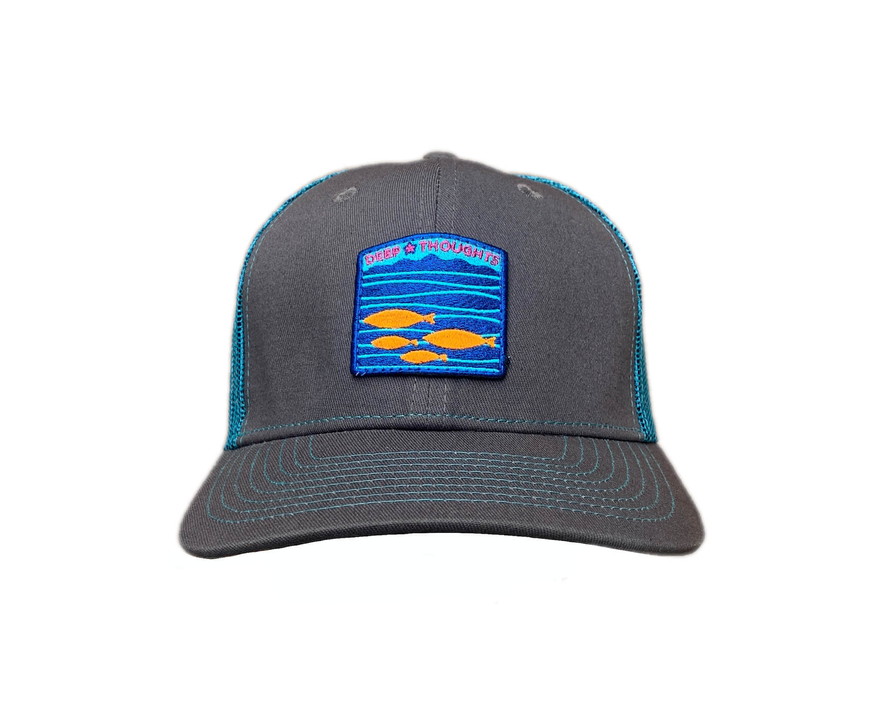 Front view of graphite and turquoise blue trucker cap with blue and orange embroidered fish under waves patch