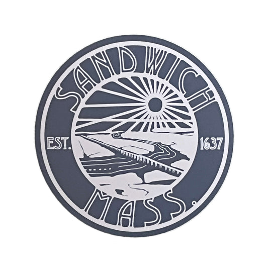 A circular blue and white Vinyl Sticker featuring the text 'SANDWICH MASS' with a stylized Sandy Neck bridge and sun graphic in the center, plus 'EST. 1637' on the sides, shown on a plain white background