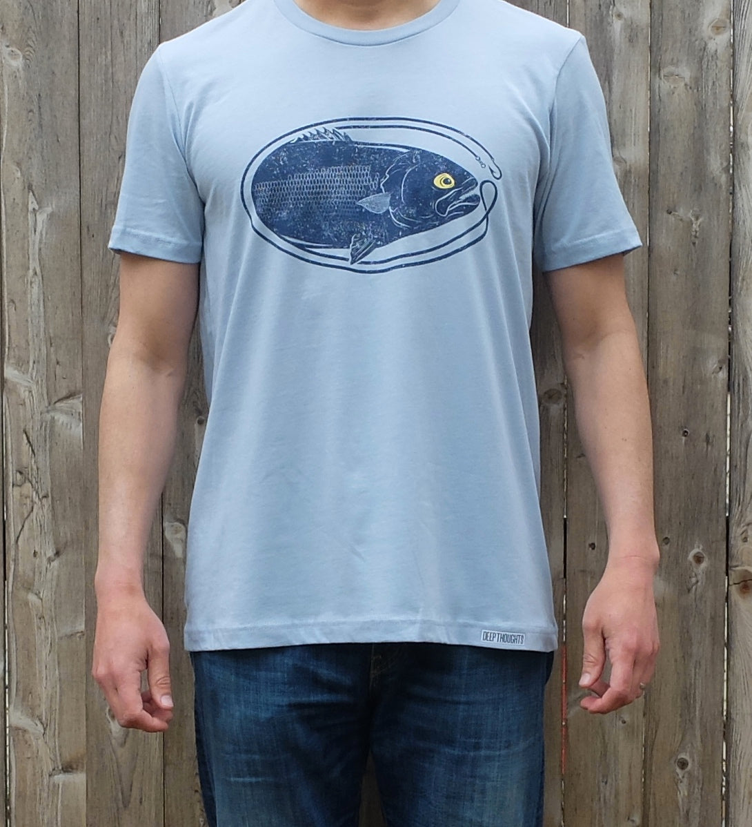 man wearing light blue cotton t-shirt with dark blue oval shaped bluefish fishing graphic
