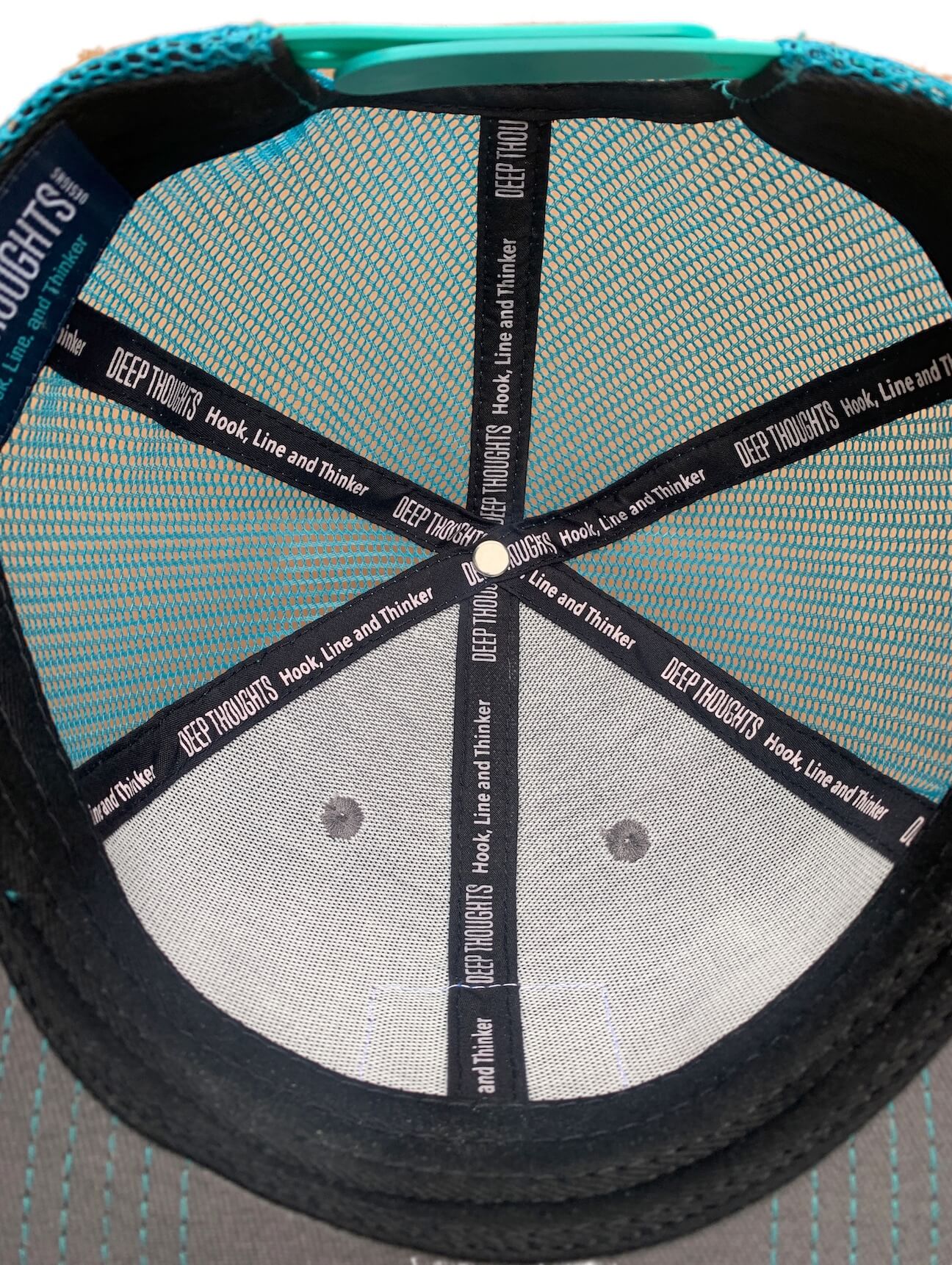 Graphite and turquoise trucker cap with custom Hook Line and Thinker tagline on inner taping