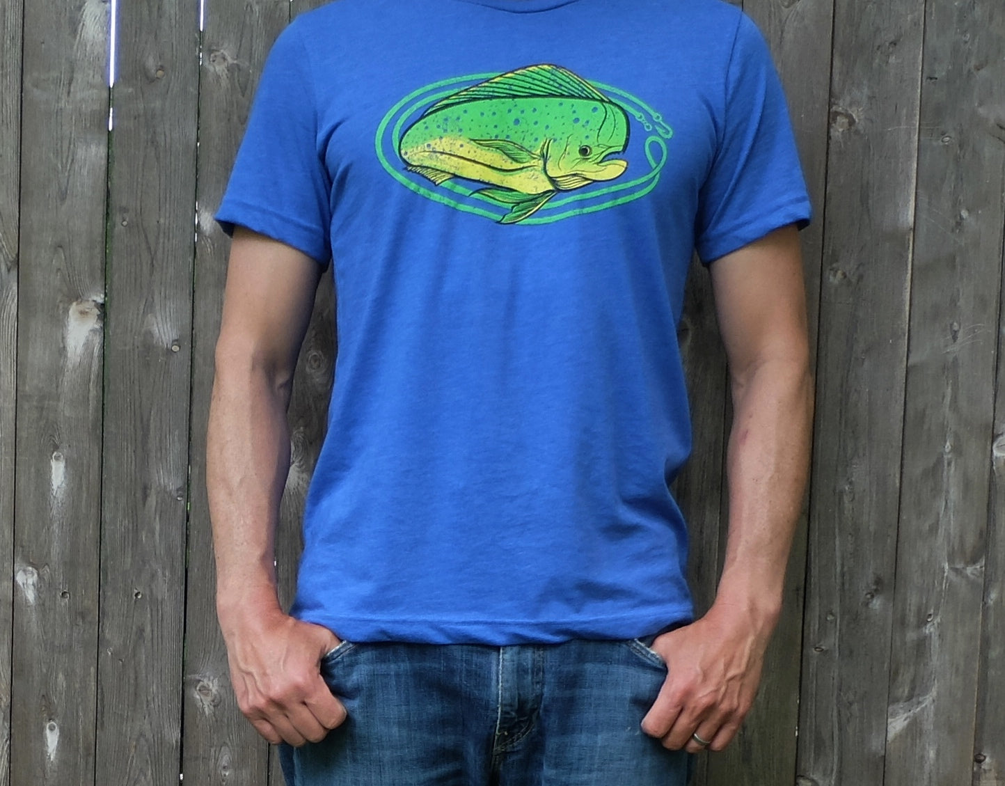 man wearing heather royal blue t-shirt with bright lime and yellow oval-shaped mahi mahi fishing graphic
