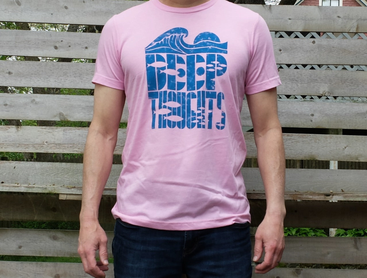 man wearing heather pink t-shirt with blue cresting wave graphic over Deep Thoughts text with fish silhouettes