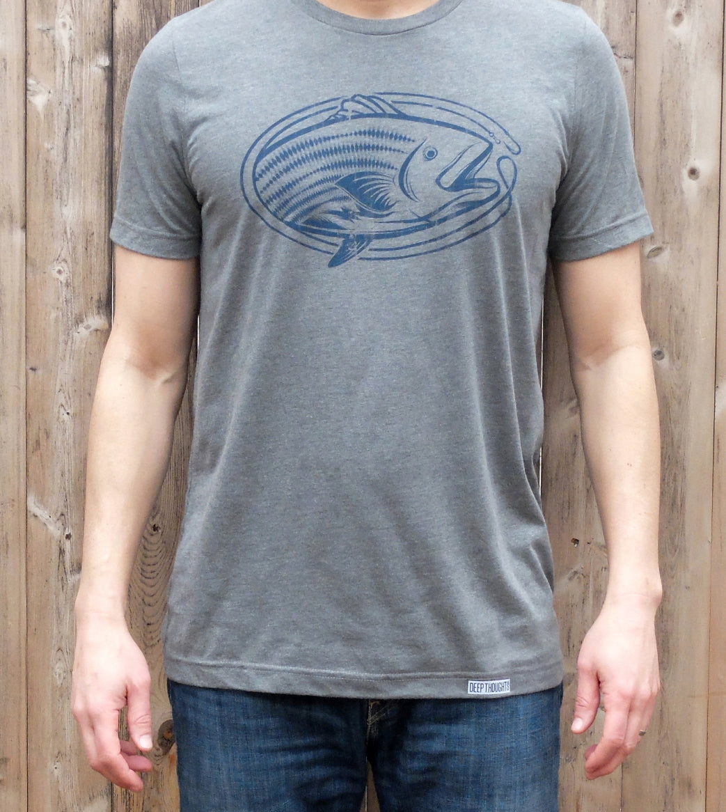 man wearing dark heather grey t-shirt with blue oval shaped striped bass fishing graphic