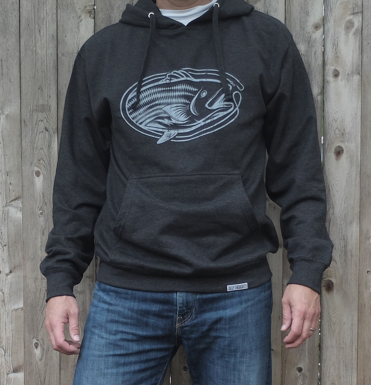 man wearing heather charcoal hoodie with white vintage style striped oval-shaped graphic