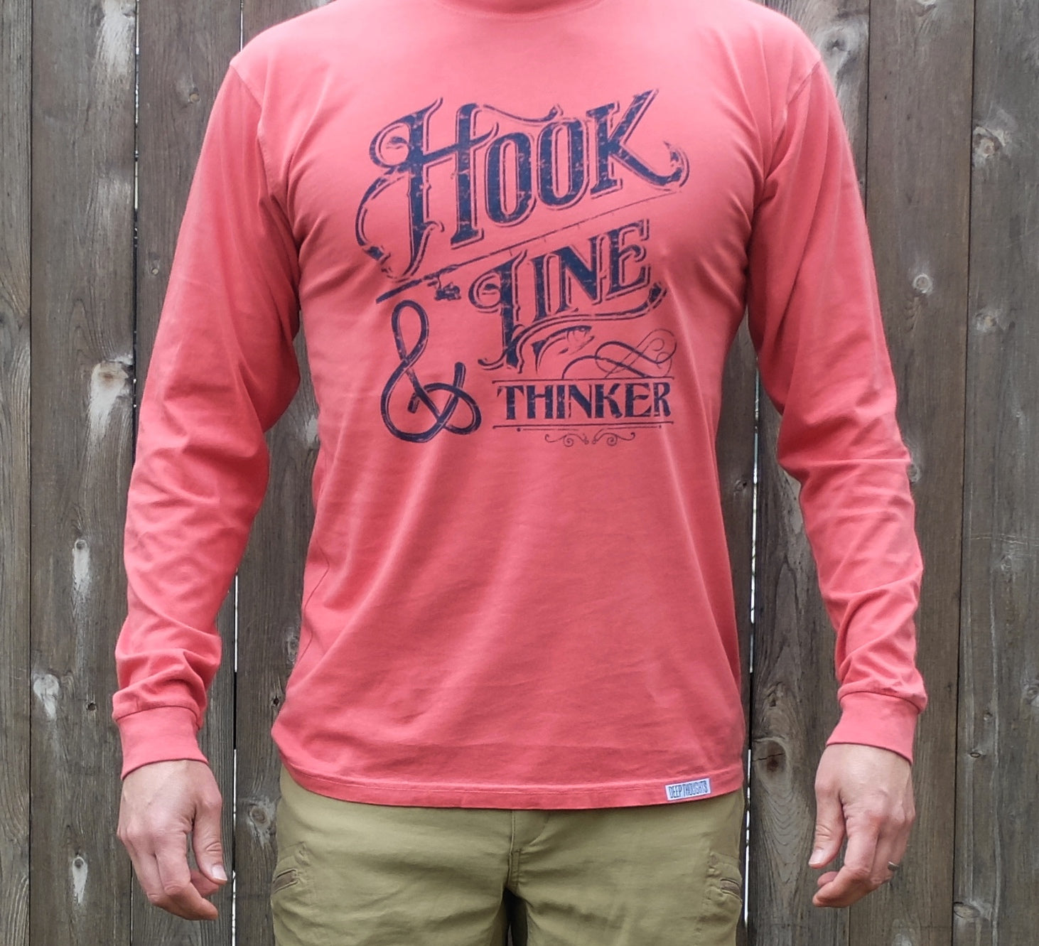 man wearing long sleeve washed red t-shirt with navy Hook Line and Thinker vintage style text