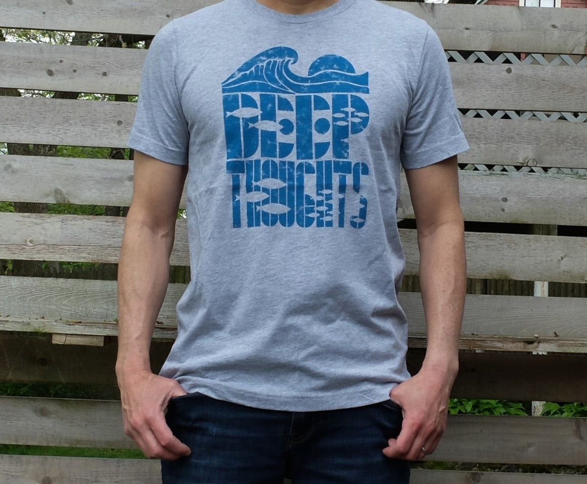 man wearing heather grey t-shirt with cresting wave graphic over 'deep thoughts' text with fish silhouettes