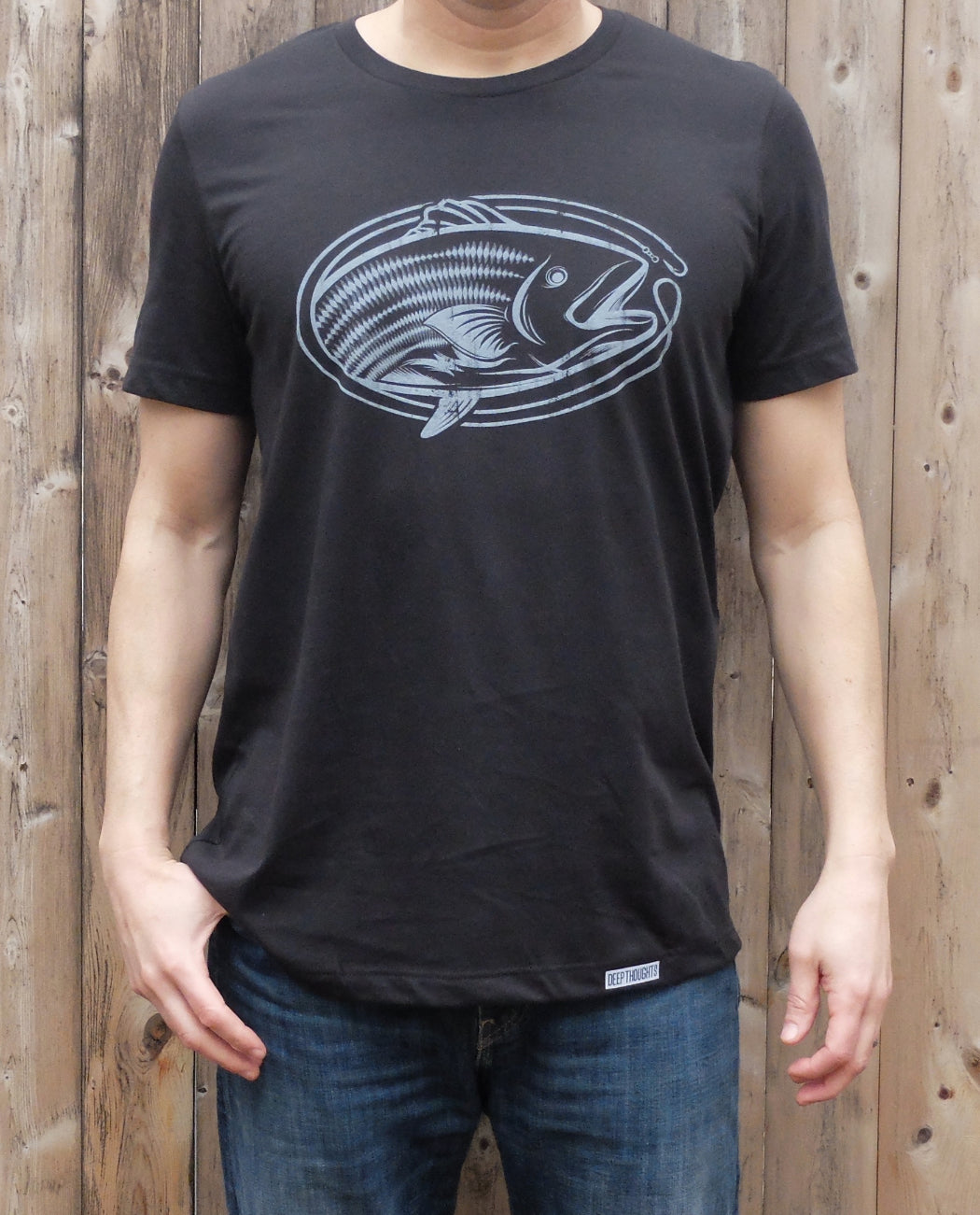 man wearing vintage black cotton t-shirt with white oval-shaped striped bass graphic