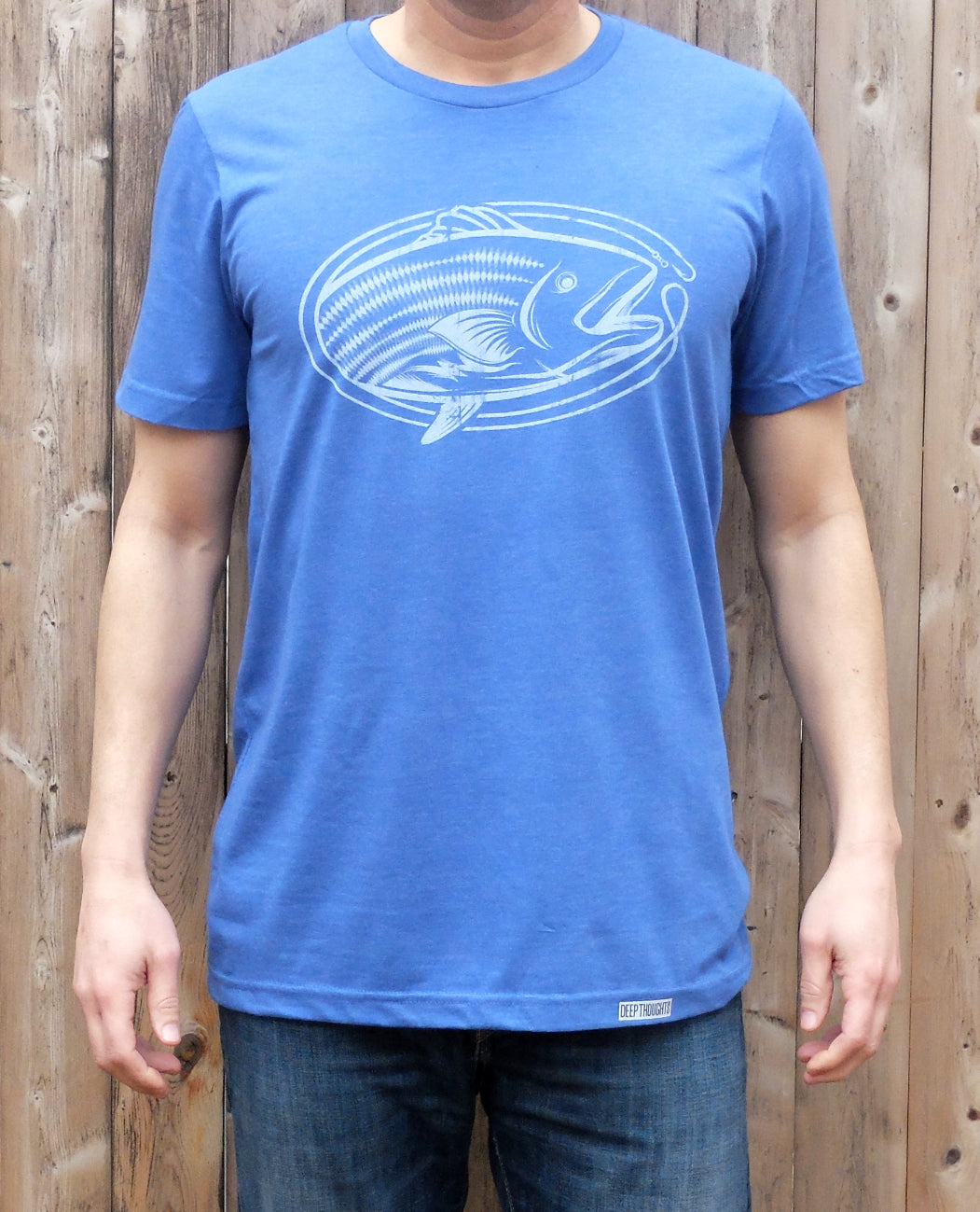 Man wearing heather royal blue t-shirt with white ova-shaped striped bass fishing graphic